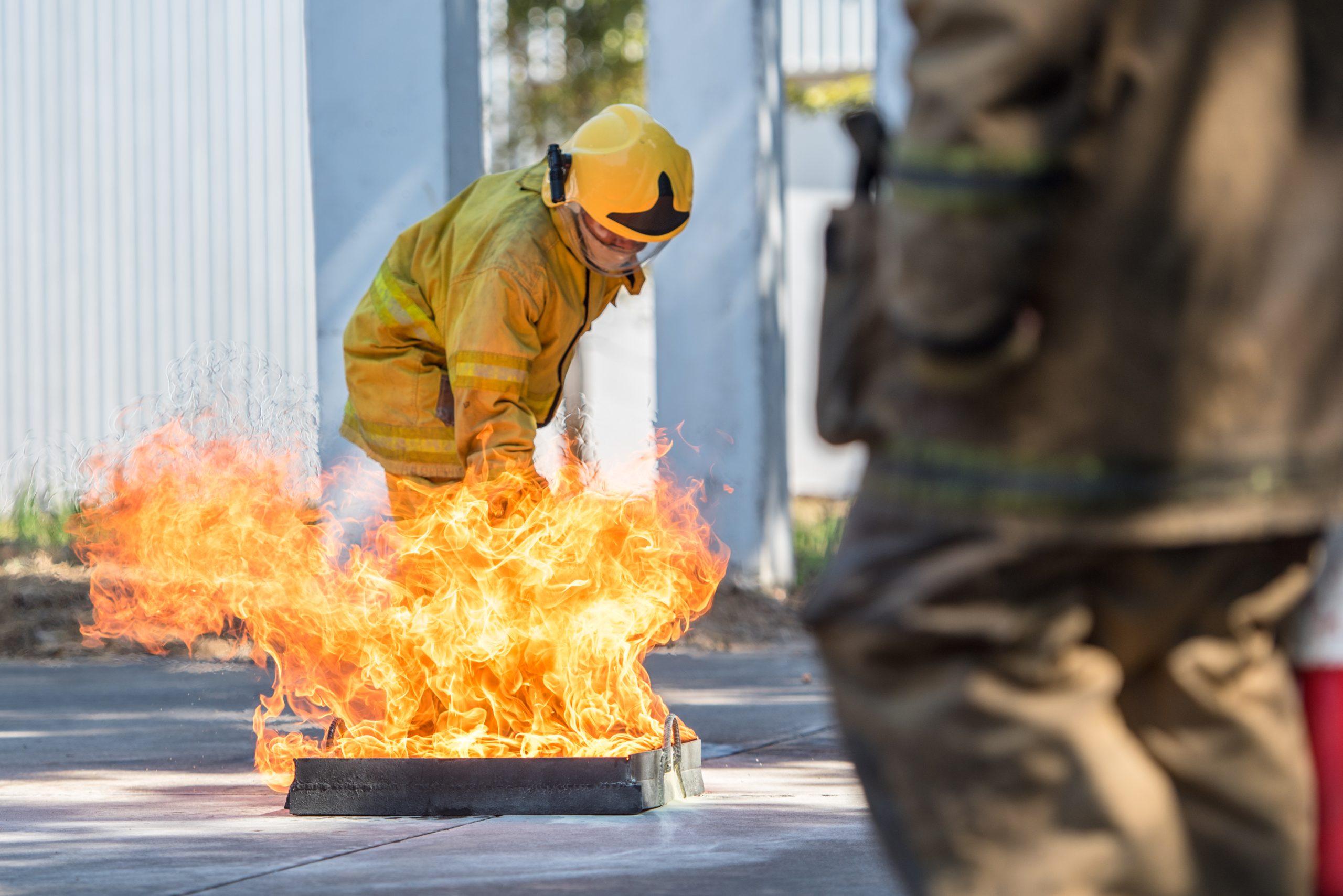 bombero-que-muestra-uso-extintor-incendios-boca-incendios-formacion-humo-blanco-concepto-seguridad-salud-laboral-scaled.jpg