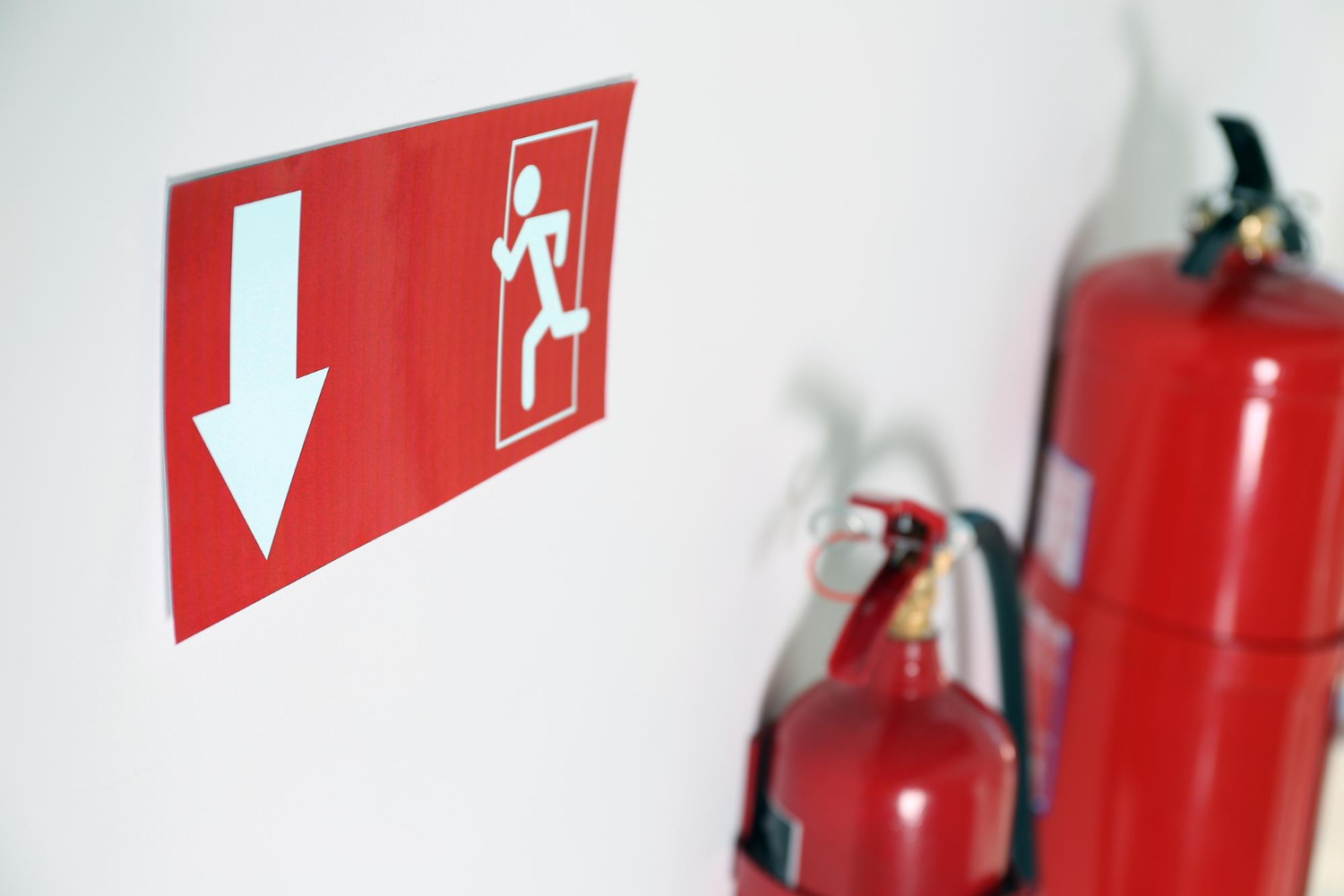 senal-salida-emergencia-extintores-primer-plano-pared-blanca.jpg